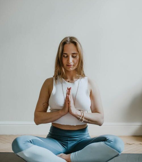 Mujer practicando yoga en una habitación luminosa