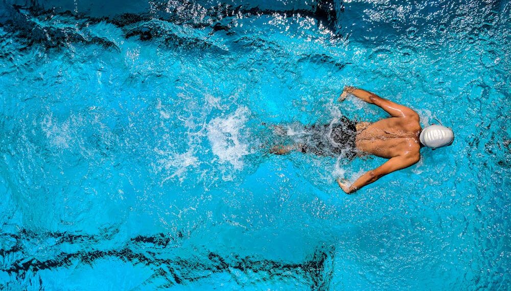 Persona nadando en una piscina con carriles