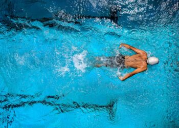 Persona nadando en una piscina con carriles